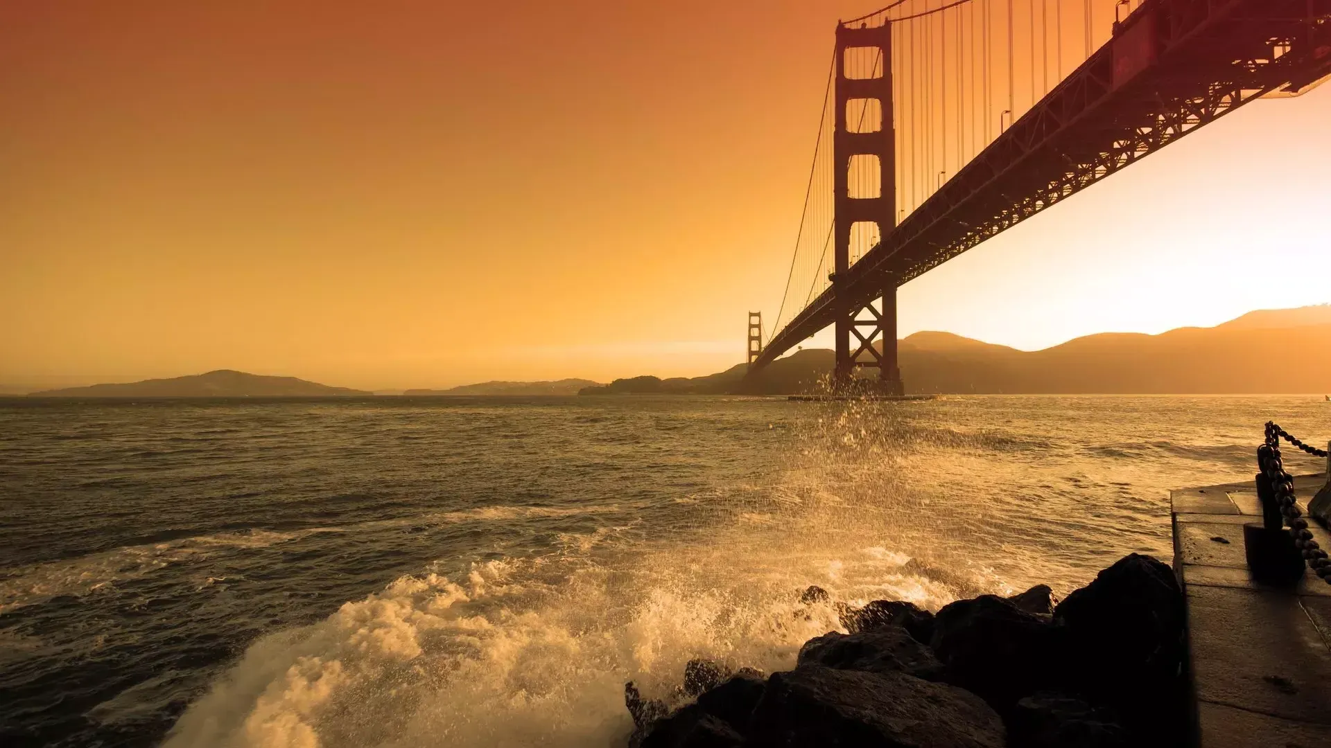 Las olas se estrellan cerca de Fort Point, debajo del Golden Gate Bridge al sunset .