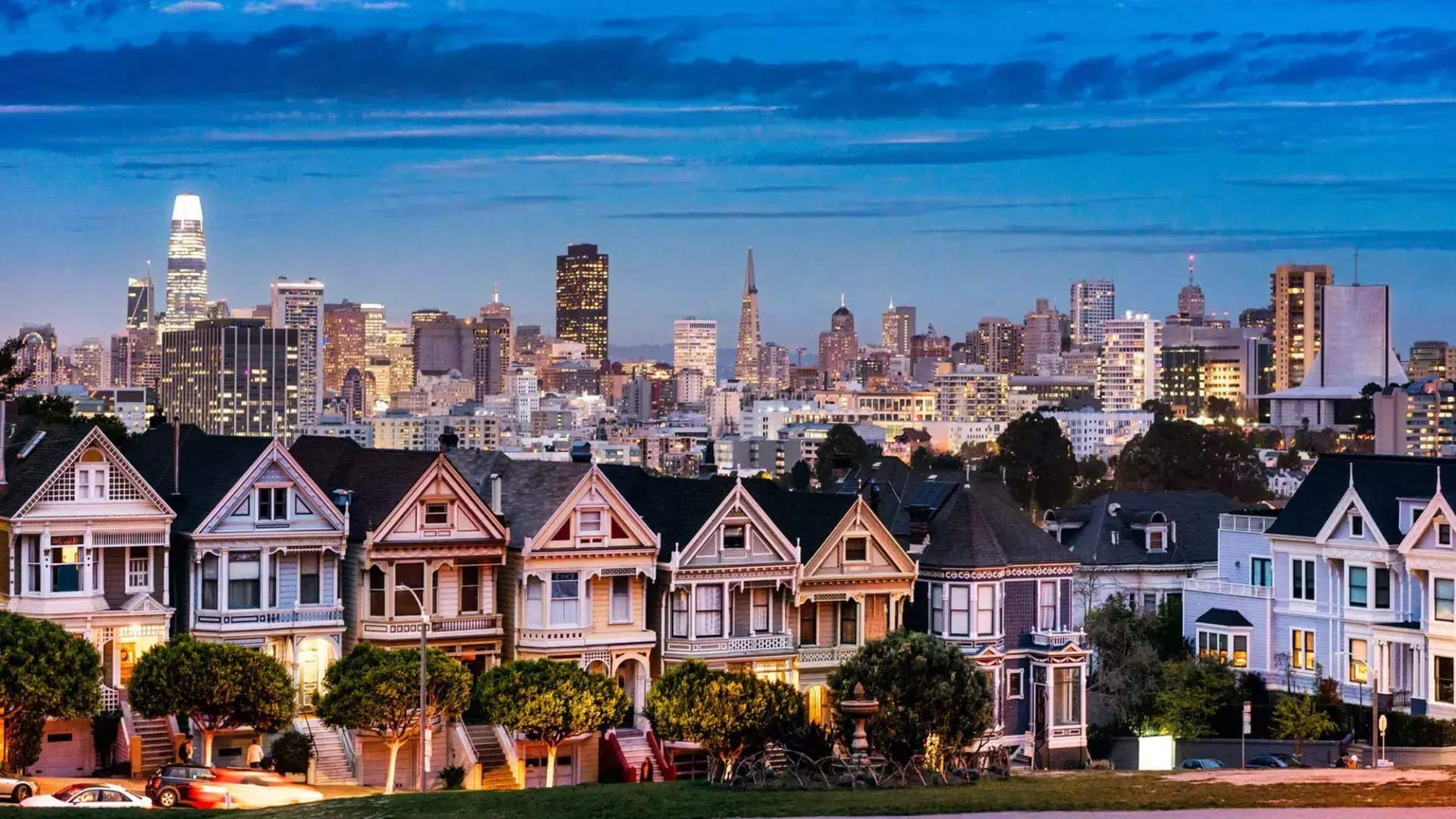 As famosas Painted Ladies da Alamo Square são retratadas diante do horizonte de São Francisco ao crepúsculo.