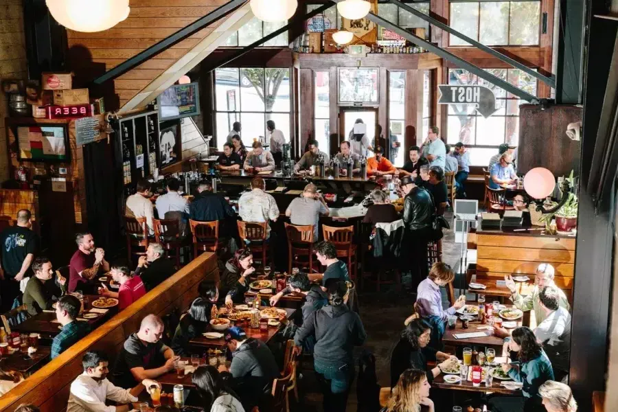 Clientes comem e bebem dentro da 21st Amendment Brewery em São Francisco.