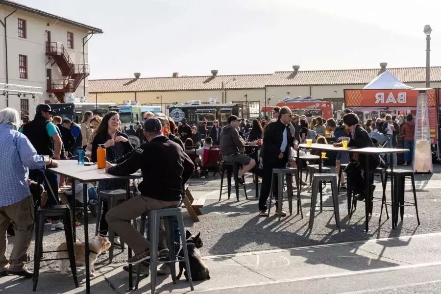 Una multitud de personas se reúne para comer en camiones de comida durante Off the Grid en Fort Mason Center.